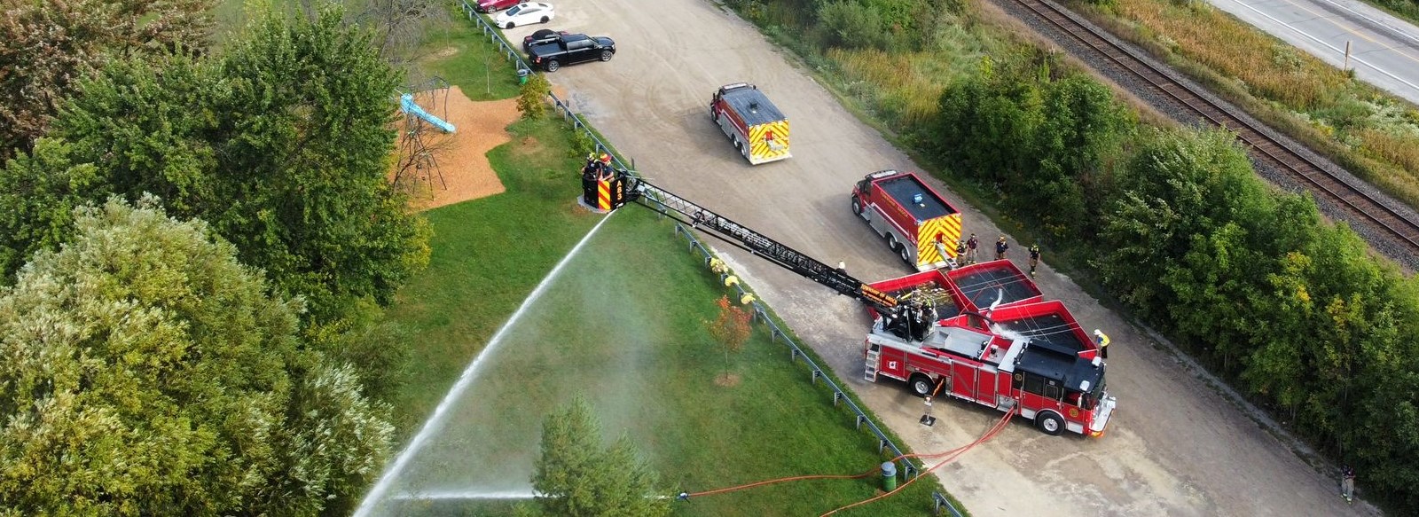 Aerial fire truck flowing water over trees 